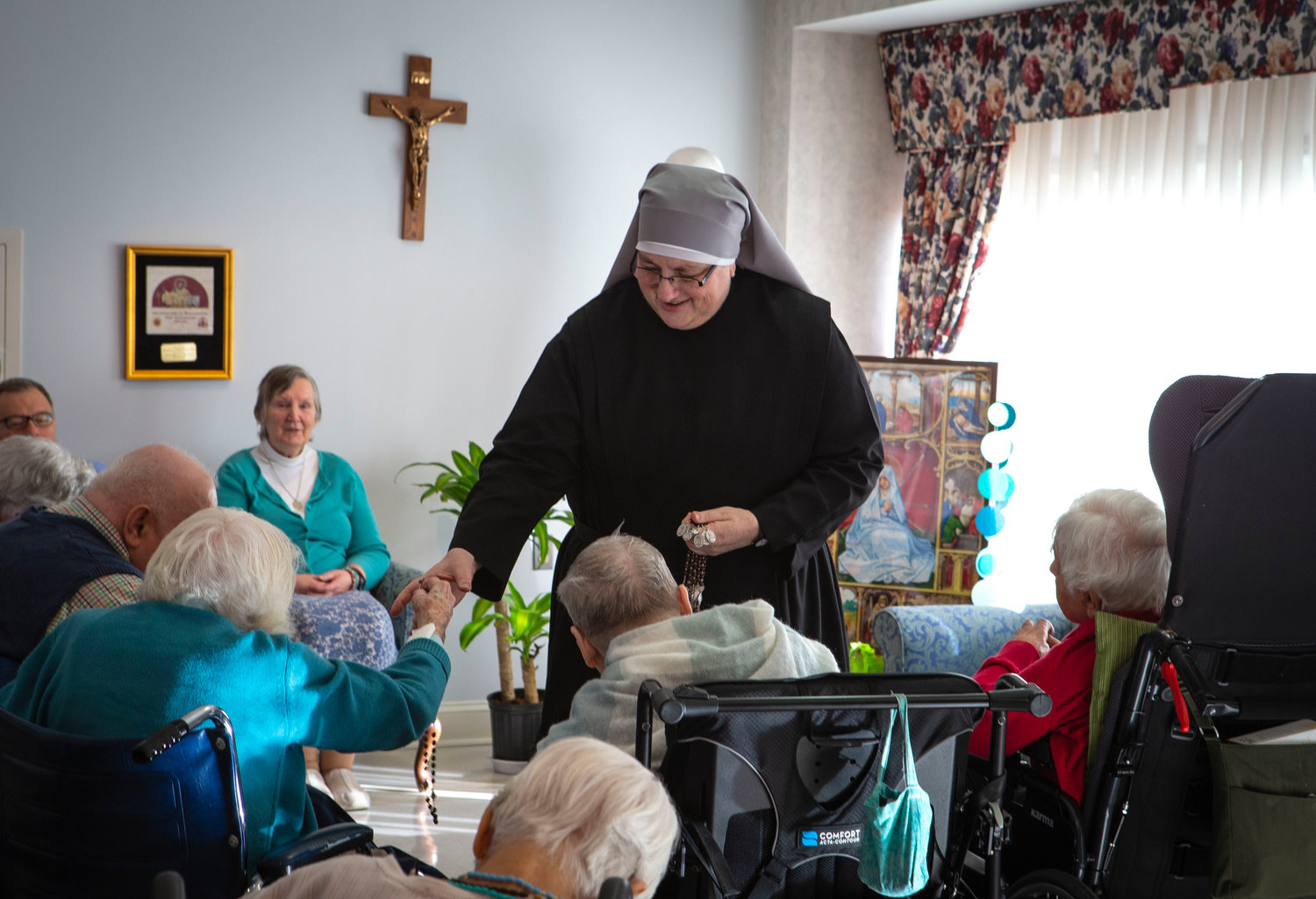 Sister Constance Veit, a Little Sister of the Poor, collects rosaries from elderly residents following prayers at the Jeanne Jugan Residence for senior care in Washington March 25, 2019. Sister Constance is considered a spiritual mother by many of the residents, who said they will honor her on Mother’s Day.